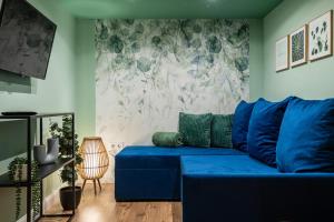 - un canapé bleu dans le salon avec un mur dans l'établissement Budapest Holidays Courtyard, à Budapest