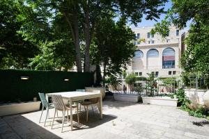 einen Tisch und Stühle in einem Innenhof mit einem Gebäude in der Unterkunft 2 BR next to Old City with Patio by FeelHome in Jerusalem