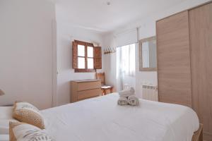 un dormitorio con una gran cama blanca con un par de zapatos. en Clauhomes Oh La Lá, en Tarragona