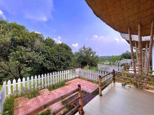 a wooden bench next to a white fence at Tilagaon Eco Village in Sreemangal