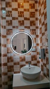 bagno con lavandino e specchio a parete di Elizabeth Hotel - Naga a Pili