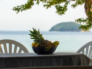 a bowl of fruit sitting on top of a table at The House On The Beach in Paleo Tsifliki