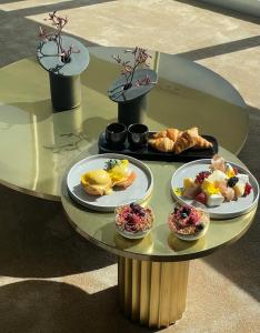 una mesa de cristal con platos de comida. en Vilnius TV Tower Apartments DEBESYS en Vilna
