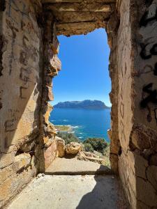 una ventana de piedra con vistas al océano en Flat Flumendosa 31, en Olbia