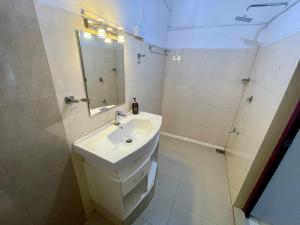 bagno bianco con lavandino e doccia di HOTEL ONE SIXTY by Luxotic Vacations a Karagampitiya