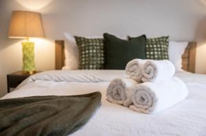 a pile of towels sitting on top of a bed at Boutique House 3B with Garden in Melbourne