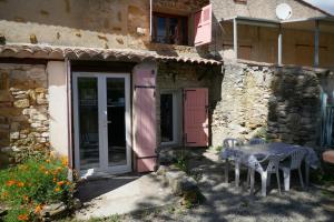 una mesa y sillas frente a una casa en Grand gîte au pays des lavandes en Aurel