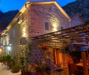 een stenen gebouw met een paraplu en een tafel bij Holiday Home Nautica in Kotor