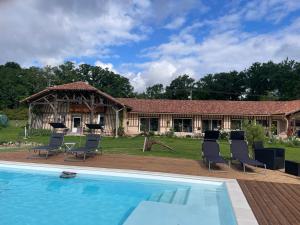 a house with a swimming pool in front of a house at L'Escafouchot de Moulère in Créon-dʼArmagnac