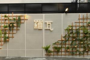 a white tiled wall with shelves with potted plants at Hotel Rawa in Seoul
