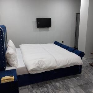 uma cama num quarto com uma televisão na parede em Hotel Crown Palace em Murree