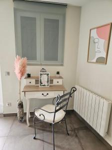 ベルフォールにあるStudio meublé - Comme à la maisonの窓付きの客室で、デスクと椅子が備わります。