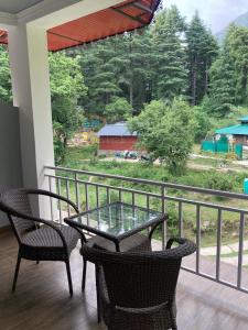 patio con mesa y sillas en el balcón en Himtrek Stays,Mcleodganj en McLeod Ganj