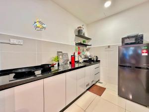 a kitchen with white cabinets and a stainless steel refrigerator at SeaView PoolView CityView BaliResidence Video game 5minJonker in Melaka
