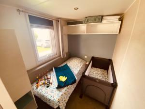 Habitación pequeña con cama y ventana en Mobilhome P27 6 personnes climatisé en Le Portel