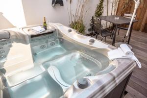 eine Whirlpool-Badewanne in einem Zimmer mit Tisch in der Unterkunft Résidence La Chaize in Noirmoutier-en-l'lle