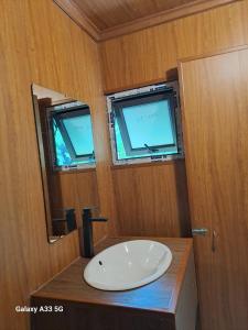 une salle de bains avec un lavabo blanc et un miroir dans l'établissement Thung Sen Tam Coc Chalets, à Ninh Binh 97 autres photos