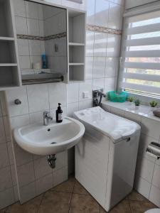 uma casa de banho branca com um lavatório e um espelho em Andrews Ferienwohnungen em Tangermünde