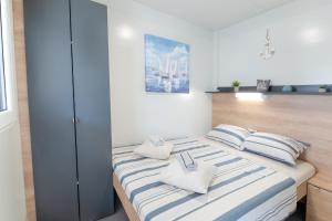 a bedroom with a bed with blue and white stripes at Mobile home Mia & Roko - Beach Porat, Drage in Drage +34 photos