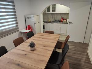 a kitchen with a wooden table and chairs at Kuća Vila Nina in Tomislavgrad
