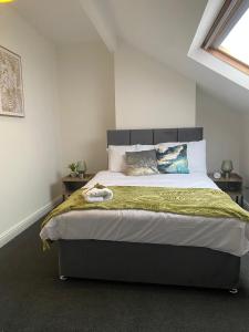 Clifton Home - Newly refurbished - Perfect for contractors! في Killingbeck: غرفة نوم بسرير كبير مع بطانية خضراء