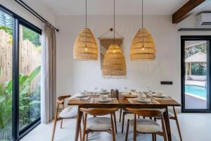 een eetkamer met een houten tafel en stoelen bij Sicilia Villa by DH Ubud in Ubud