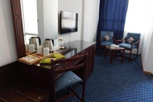 a hotel room with a desk and a mirror at Amon Alexandria in Alexandria