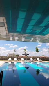 een groot zwembad met stoelen en een parasol bij Afyon Regulus Thermal Apart Hotel & Villas in Gazligol