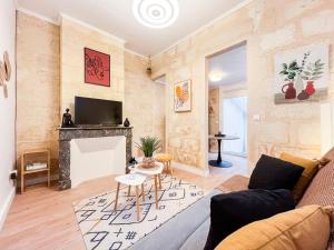 a living room with a couch and a fireplace at Echoppe typique avec Terrasse in Talence