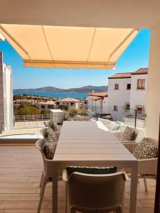 a table on a balcony with a view of the ocean at Resort Le Maree Cannigione in Cannigione