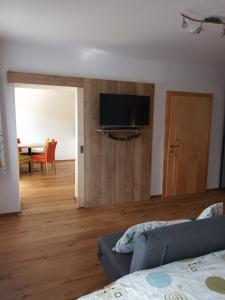 ein Wohnzimmer mit einem Sofa und einem TV an der Wand in der Unterkunft Landhaus Ebner in Millstatt