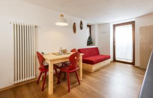 a living room with a table and chairs and a couch at La Marmote Albergo Diffuso di Paluzza Clome in Paluzza