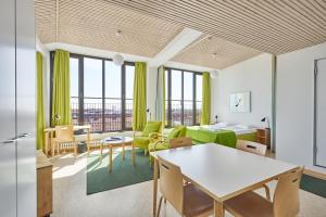 a living room with green furniture and windows at Töölö Towers in Helsinki