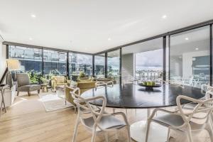 an open living room with a table and chairs at VAQUAY Embassy In Abbotsford in Melbourne
