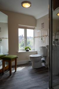 a bathroom with a toilet and a window at The Plumb Townhouse in Warwick Centre in Warwick