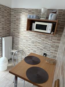 a kitchen with a wooden table and a microwave at Afamado apartman Fisli in Hévíz
