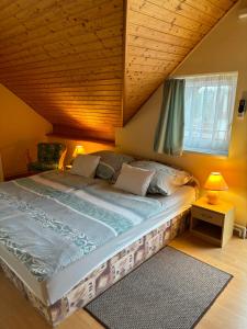 1 dormitorio con 1 cama grande y techo de madera en Afamado apartman Fisli en Hévíz