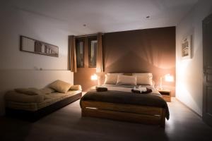 1 dormitorio con cama y sofá en B&B Maison d'hôte et gite Mas d'Eymard, en Arles