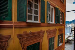 a building with green windows and green shutters at Cozy Little House in Camogli by Wonderful Italy in Camogli