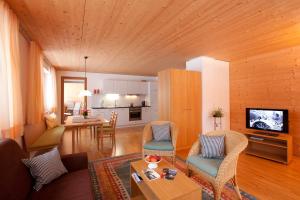 ein Wohnzimmer mit einem Sofa und Stühlen sowie eine Küche in der Unterkunft Hotel Gasthof Wälderhof in Lingenau