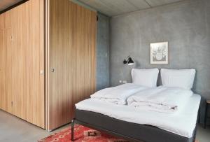 ein Schlafzimmer mit einem großen Bett mit weißer Bettwäsche in der Unterkunft Hotel GUESTapart in Arhus