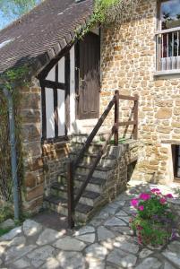 a brick building with a staircase leading to a door at Les Roses, avec piscine, tennis et lac privatif in Guerquesalles