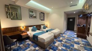 una stanza d'albergo con due letti e una sedia di Harris Hotel a Tashkent