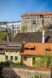 um grupo de telhados com um castelo ao fundo em Apartments Dlouhá 93 em Český Krumlov