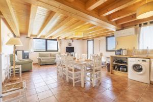 eine Küche und ein Wohnzimmer mit einem Tisch und Stühlen in der Unterkunft El Refugi De Rubinat in Sant Antolí i Vilanova