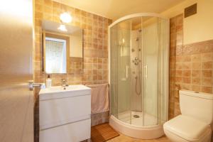 a bathroom with a shower and a toilet and a sink at El Refugi De Rubinat in Sant Antolí i Vilanova