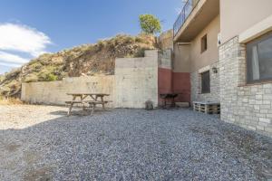 a picnic table next to a building with a hill at El Refugi De Rubinat in Sant Antolí i Vilanova
