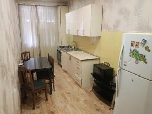 eine Küche mit einem Tisch und einem weißen Kühlschrank in der Unterkunft beautiful flat/apartment in Tbilisi City