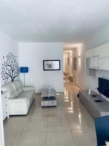 Sala de estar blanca con sofá y mesa en Holiday Apartment, Gzira, Malta, en Il-Gżira