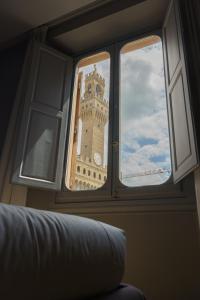 a view of a clock tower through a window at Signoria n&deg;5 in Florence